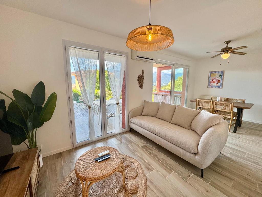 a living room with a couch and a table at Deux pièces tout confort sur les hauteurs de Propriano in Propriano