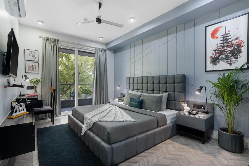 Un dormitorio con una cama grande y un sofá. en BedChambers Serviced Apartments, MG ROAD, en Gurgaon