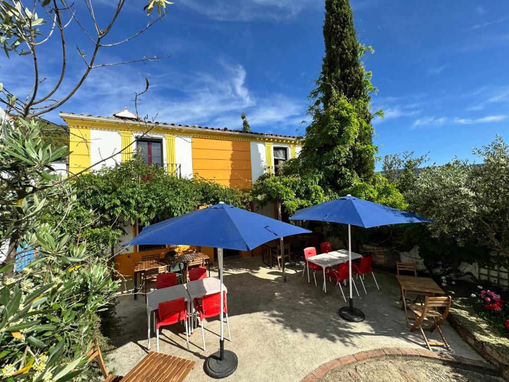 a patio with tables and chairs and umbrellas at Salto del Caballo in La Fontañera