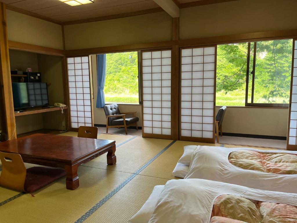 Postel nebo postele na pokoji v ubytování 料理自慢の温泉宿せせらぎ荘