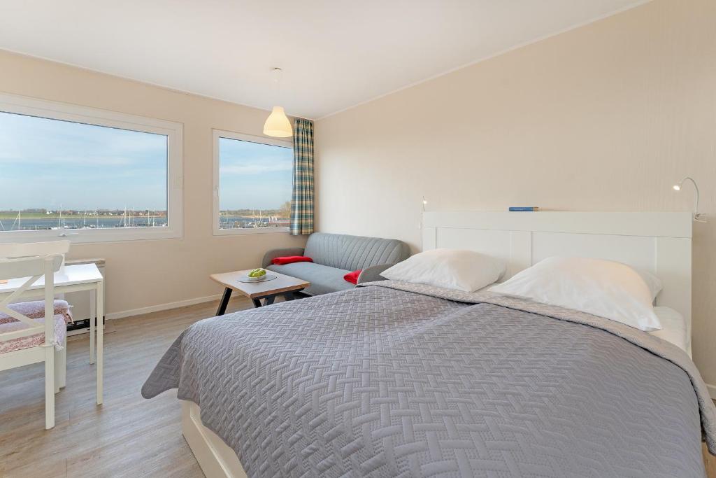 a bedroom with a bed and a desk and a window at Weitblick in Burgtiefe auf Fehmarn 