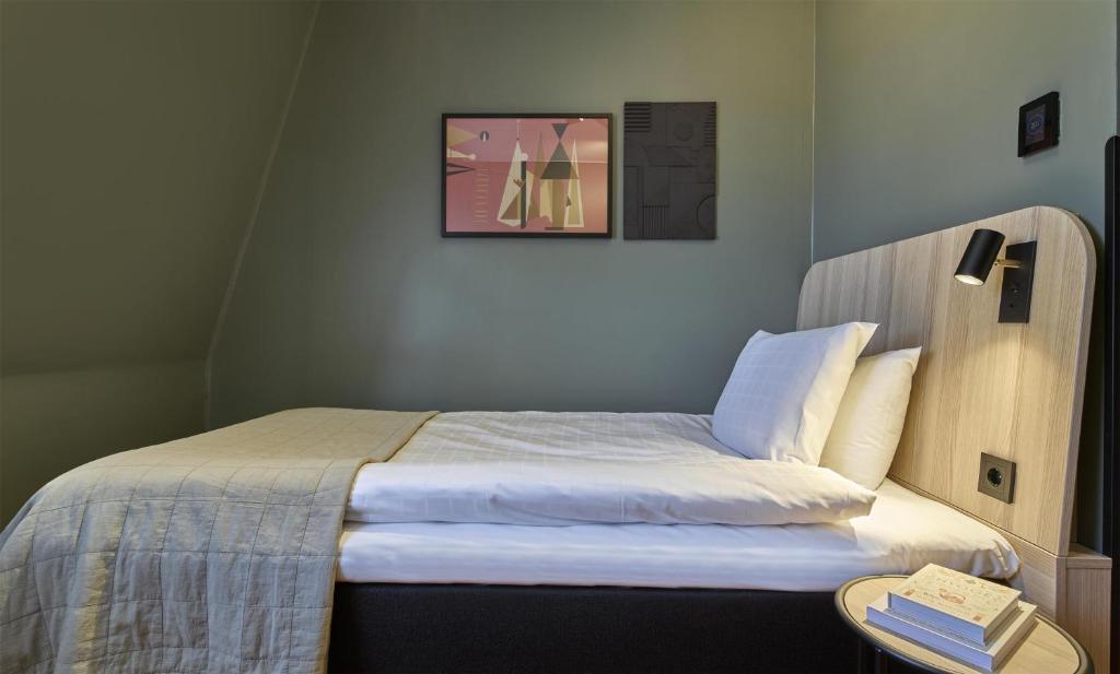 a small bedroom with a bed with white sheets at Scandic Malmen in Stockholm