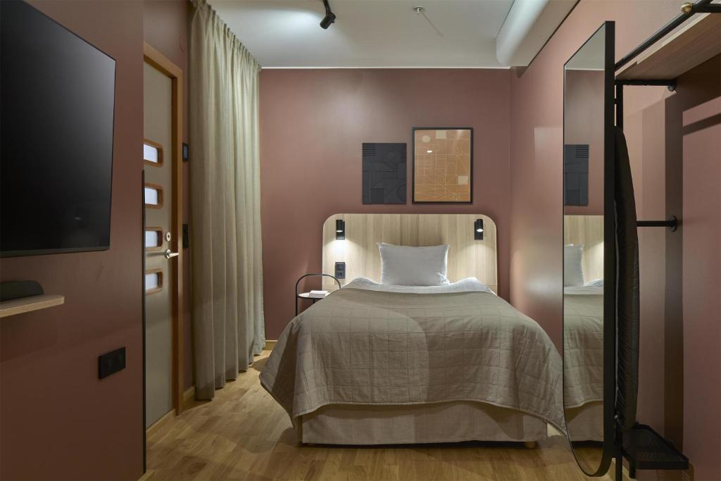 a bedroom with a bed and a flat screen tv at Scandic Malmen in Stockholm