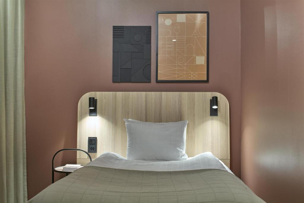a bedroom with a bed with a white pillow at Scandic Malmen in Stockholm