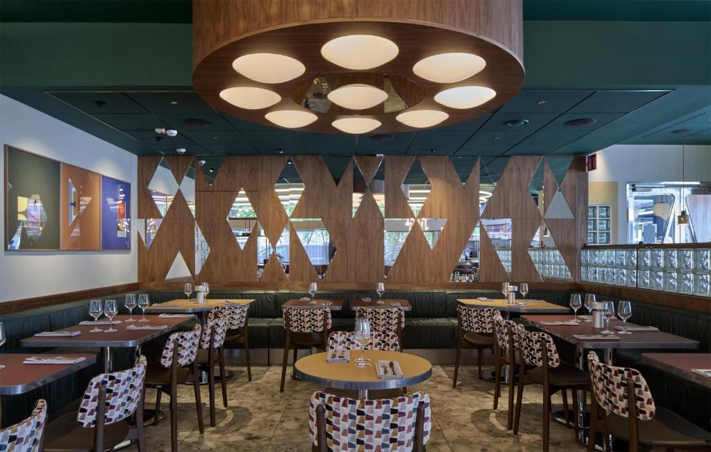 a dining room with tables and chairs and a chandelier at Scandic Malmen in Stockholm