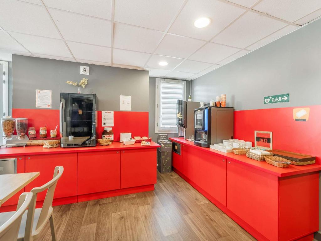 a kitchen with red cabinets and a red counter at hotelF1 Lyon Bourgoin-Jallieu in LʼIsle-dʼAbeau