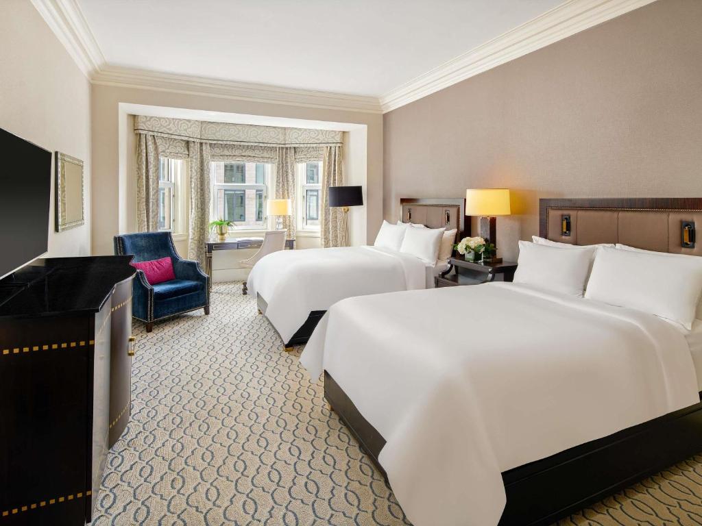 a hotel room with two beds and a chair at Fairmont Chateau Laurier in Ottawa