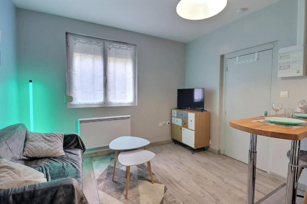 a living room with a couch and a table at Les Apparts du Pont Vert - lit double - WiFi - tout inclus - 5 in Troyes
