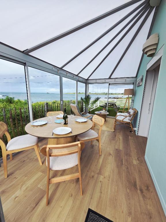 une salle à manger avec une table et des chaises dans l'établissement Charmante maison avec vue mer panoramique et acces direct aux magnifiques plages, à Plouguerneau