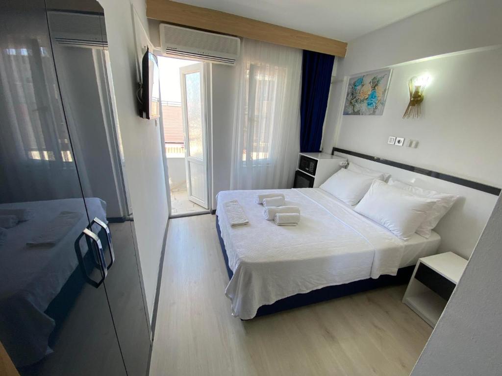 ein kleines Schlafzimmer mit einem weißen Bett und einem Fenster in der Unterkunft Acer Güneş Otel in Didim