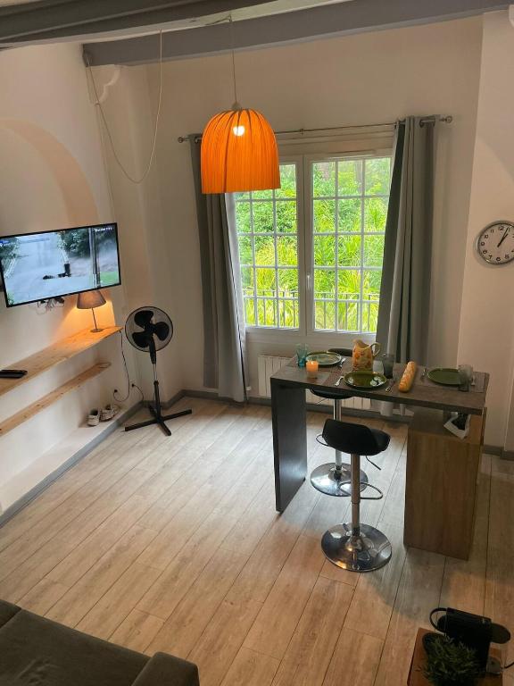 un salon avec une table et une télévision dans l'établissement Studio - Cagnes-sur-mer, à Cagnes-sur-Mer