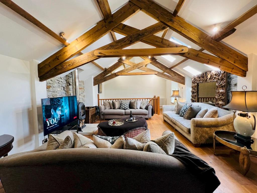 ein Wohnzimmer mit Sofa und Fernseher in der Unterkunft Pass the Keys Stunning 3-Bed Cottage Shepherd Hut Peak Views in Castleton