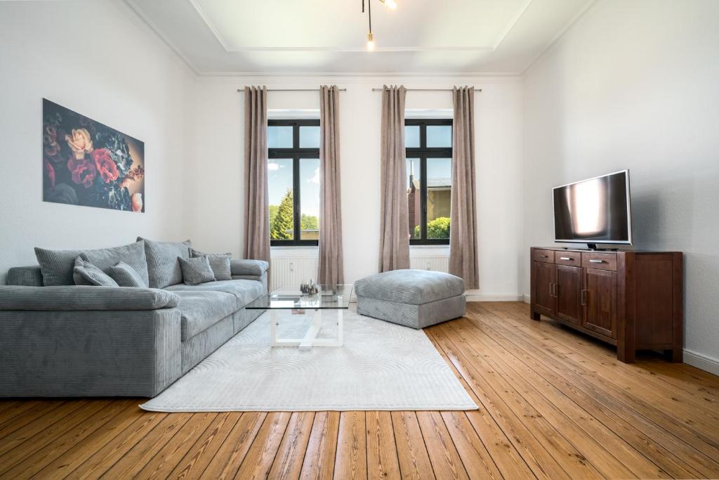 a living room with a couch and a tv at InselLiebe mit Seeterrasse in Malchow