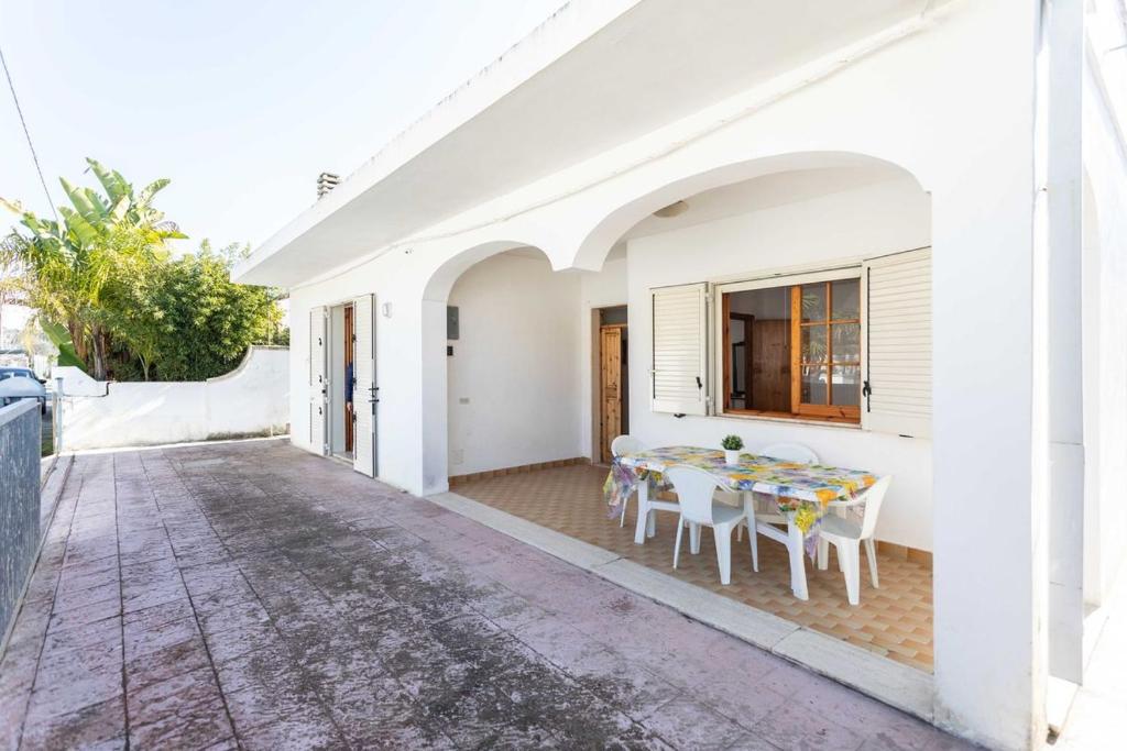 Lido ConchigliaにあるVilletta Bouganville - Salento Reservationの白い家(テーブル、椅子付)