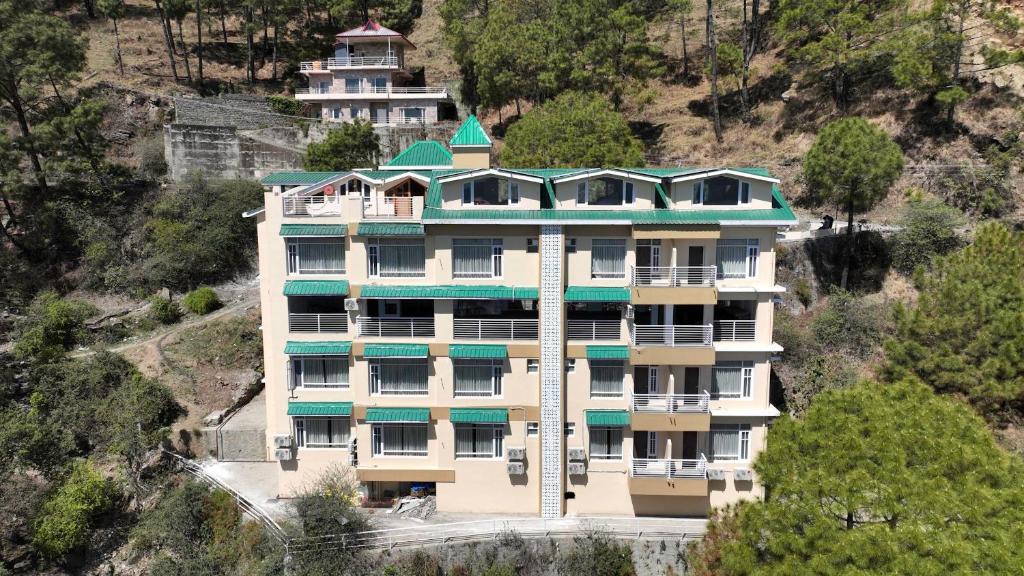 a large building on the side of a mountain at Rajgriha Luxury Kasauli Stay in Kasauli