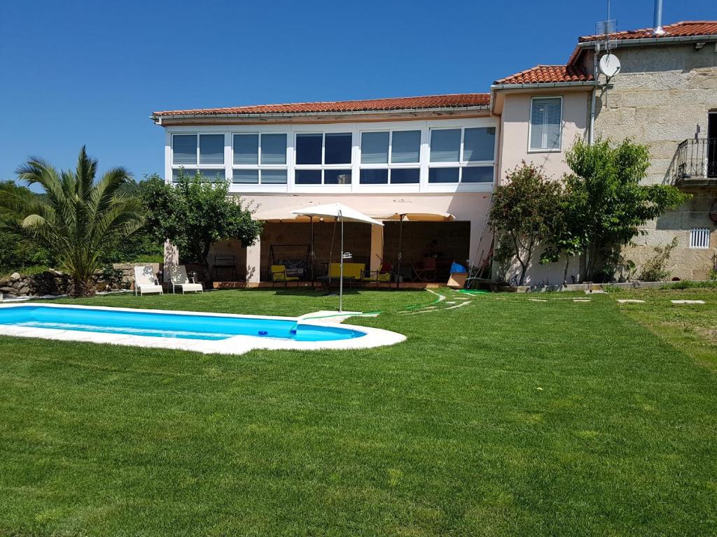 a large yard with a pool in front of a house at Palleira da Meiroá in Esgos