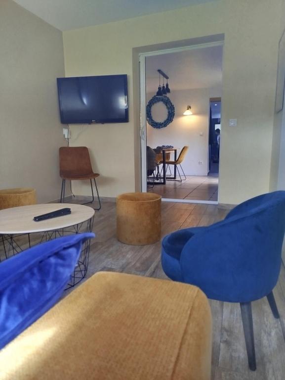 un salon avec des chaises bleues et une table dans l'établissement Maison spa de nage port plage bassin d'Arcachon, à Audenge