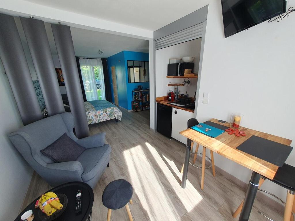Elle comprend un petit salon doté d'un bureau et d'une chaise. dans l'établissement Appartement 50m2 indépendant dans maison familiale, à Arnage