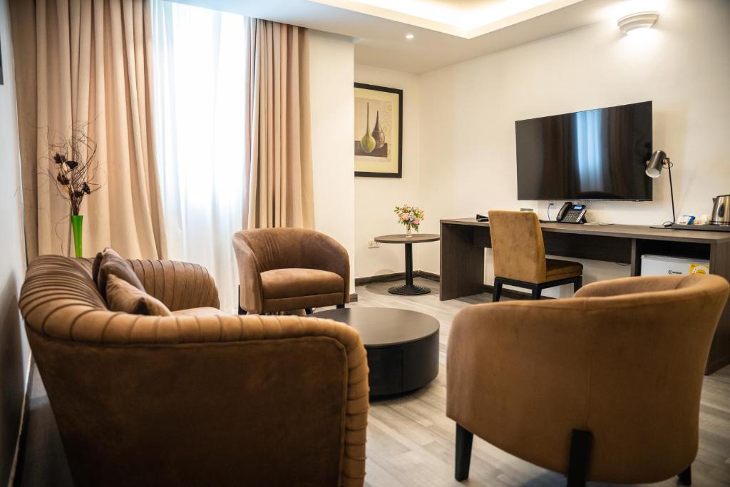 阿克拉Alisa Hotel North Ridge的客厅配有沙发、椅子和书桌