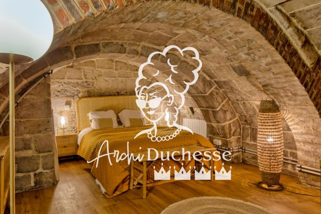 ein Schlafzimmer mit einem Bett in einer Ziegelwand in der Unterkunft Le Nid Vouté charmant appartement avec terrasse situé au coeur de Rouen in Rouen