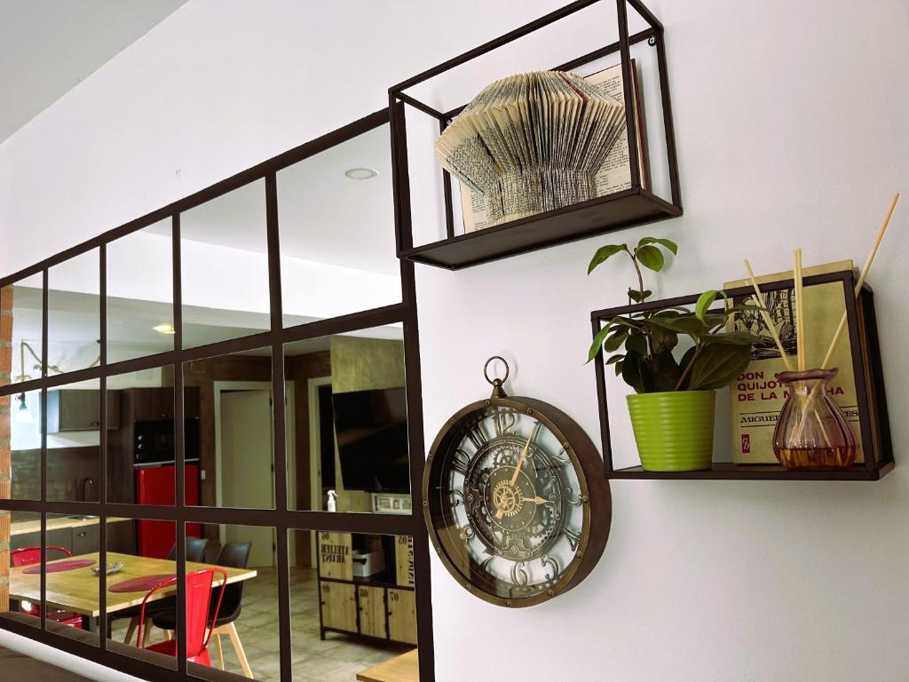 a clock hanging on a wall with shelves at Ohana Raiz Casa con Patio Parking Gratuito y Exclusivo in Merida