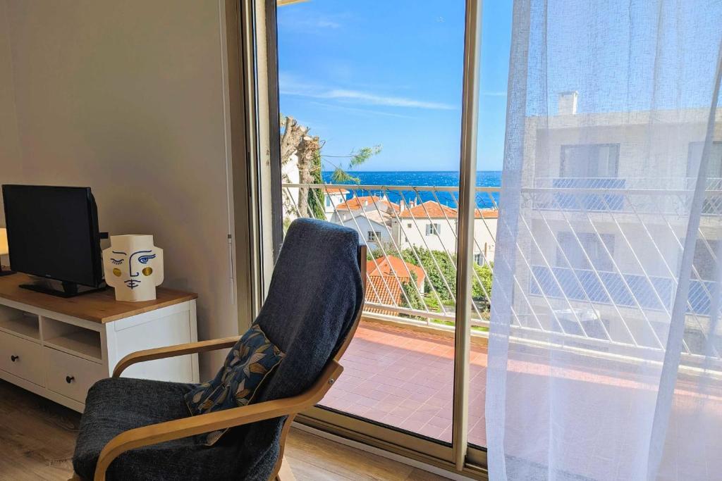une chaise en face d'une fenêtre avec vue sur l'océan dans l'établissement Apartment for 2 - sea view, à Toulon