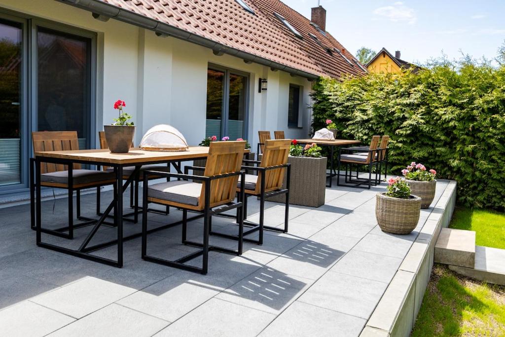 a patio with a wooden table and chairs at Haus Grande-Familienidyll am See in Neubrandenburg