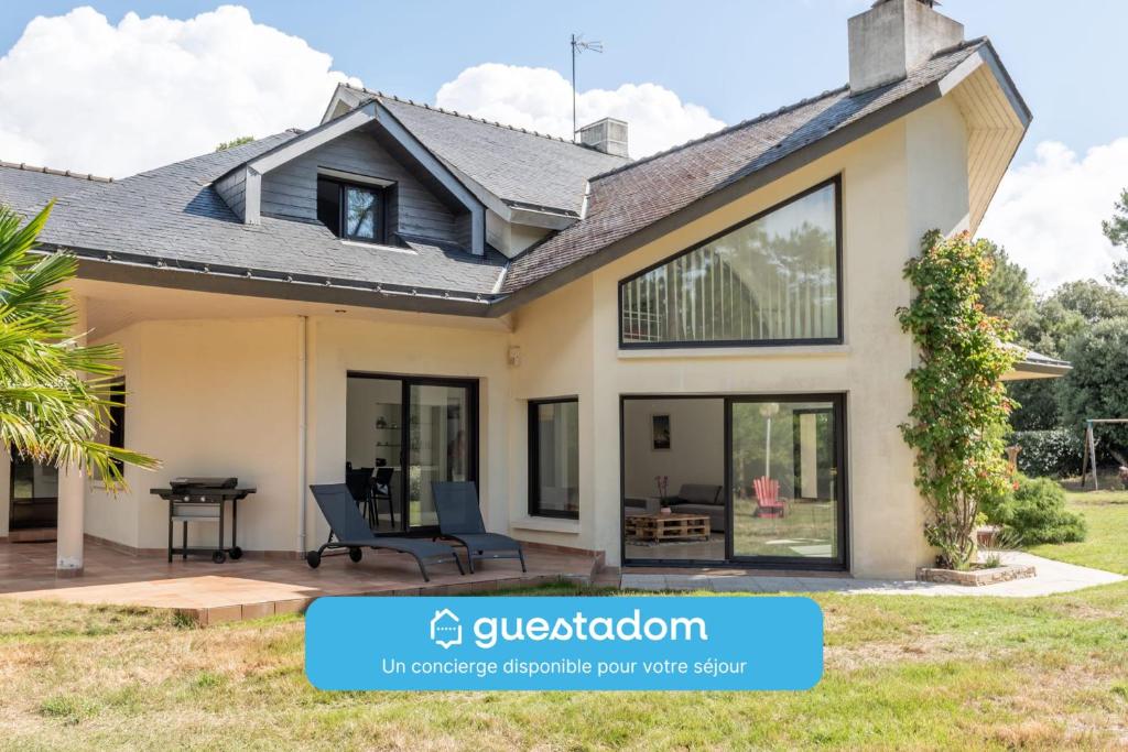 une maison avec de grandes fenêtres et un toit dans l'établissement LA BOUSSOLE- Maison 8 personnes, à Pornichet