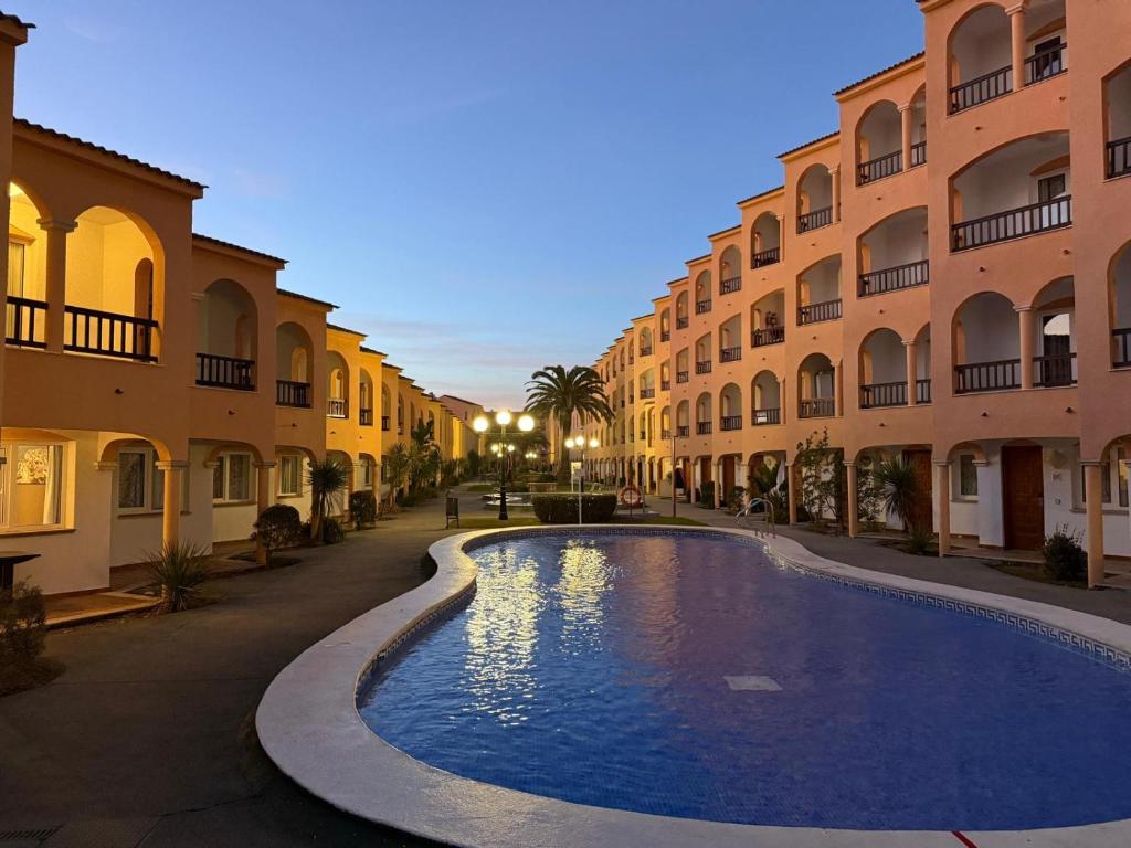 a swimming pool in a courtyard between two buildings at Apartamentos turísticos Jardines de Plaza in Peñíscola