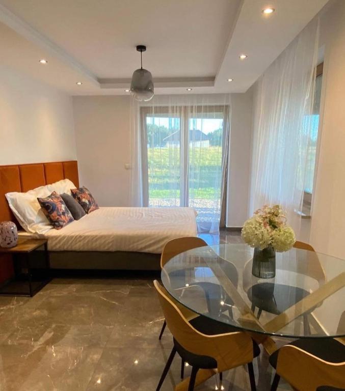 a bedroom with a bed and a glass table at Agro Komfort in Bakałarzewo