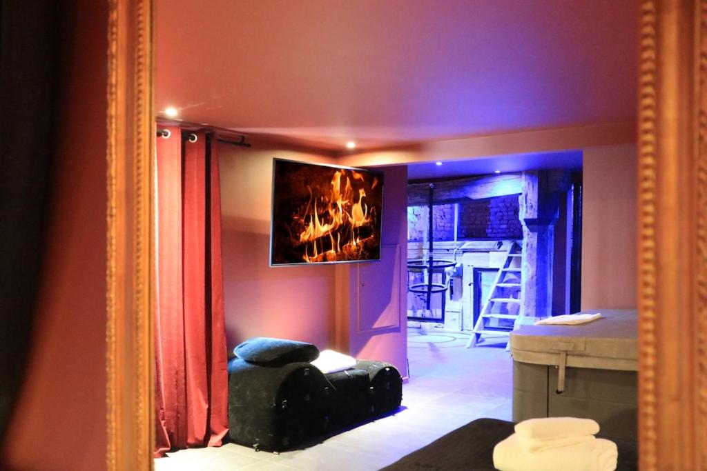 Un reflejo en el espejo de una habitación con una pieza de equipaje. en LE MOULIN DES PLAISIRS atypical SM experience, en Wentzwiller