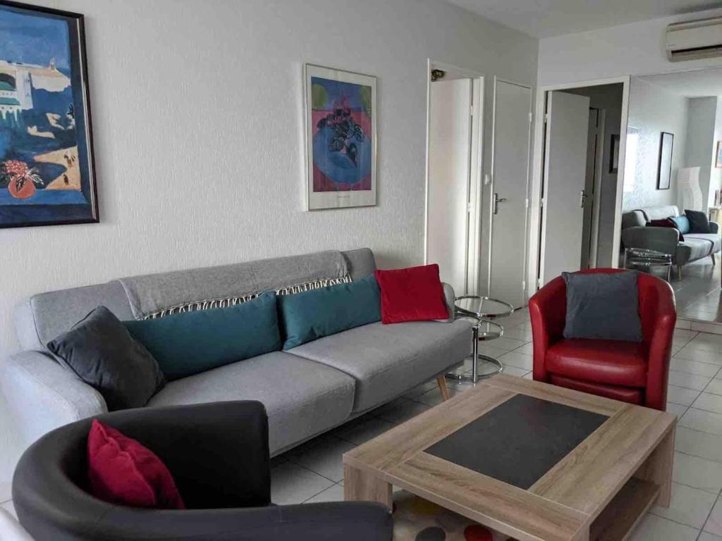 un salon avec un canapé et une table dans l'établissement Spacious 2 BR 1 block from beaches - and the TRAM, à Nice