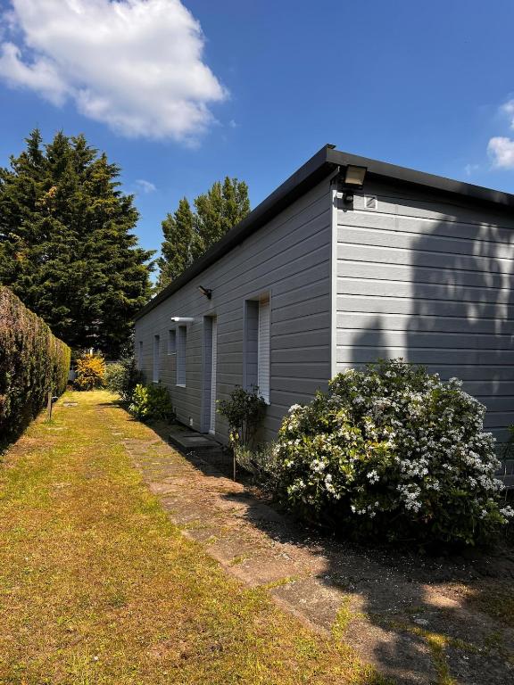 un bâtiment gris avec une cour devant lui dans l'établissement Le Grand Air, à Bréville-sur-Mer