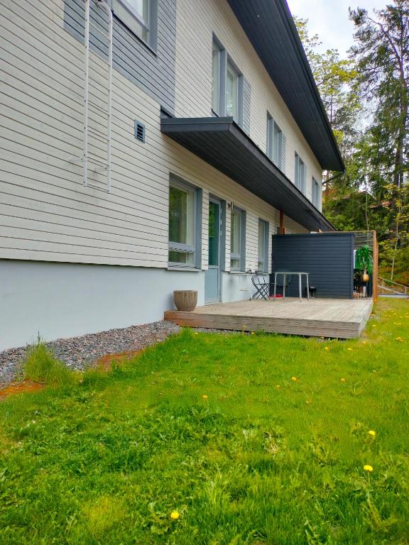 a backyard of a house with a wooden deck at Apartment & BBQ & free parking in Espoo