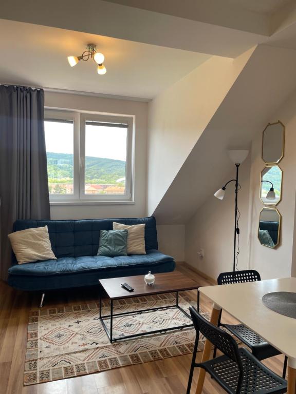 a living room with a blue couch and a table at 7 people - 1 price - Cozy attic apartment in Prešov