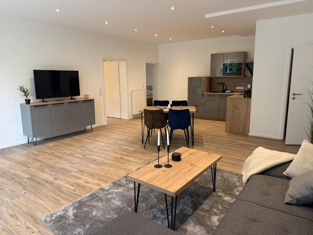 a living room with a couch and a table and a kitchen at Klosterhof Aue W 14 in Bad Zwischenahn