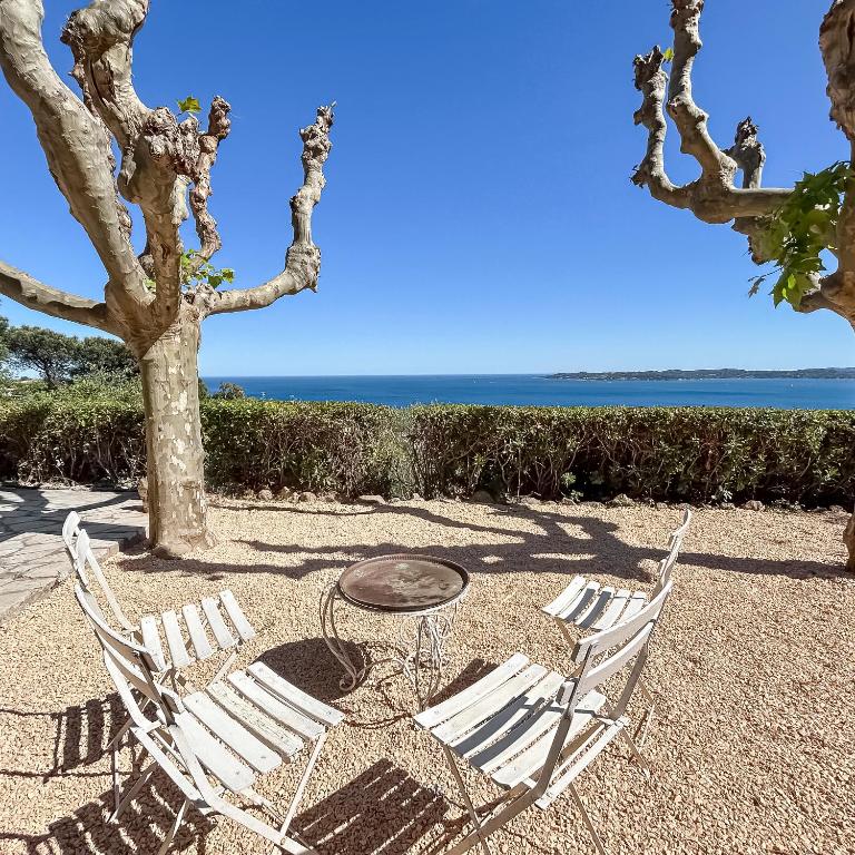 2 chaises, une table et un arbre dans l'établissement Détente provençale avec vue mer, à Sainte-Maxime