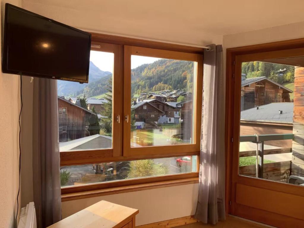 Cette chambre dispose d'une grande fenêtre et d'une télévision à écran plat. dans l'établissement Studio 2 étoiles lumineux à 600m du centre de Morzine avec tennis privatif et navette gratuite - FR-1-679-1, à Morzine