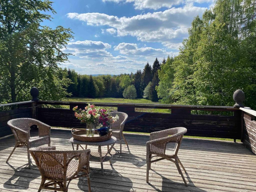 un patio con tavolo e sedie su un ponte di Jägerwohnung im Forsthaus am Schindelbruch a Stolberg i. Harz
