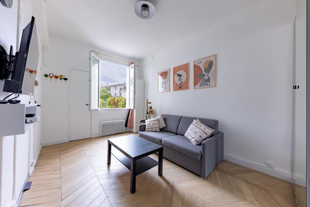 un salon avec un canapé et une table dans l'établissement Romantic 3 Stars - Studio suite by Canal Saint-Martin, à Paris