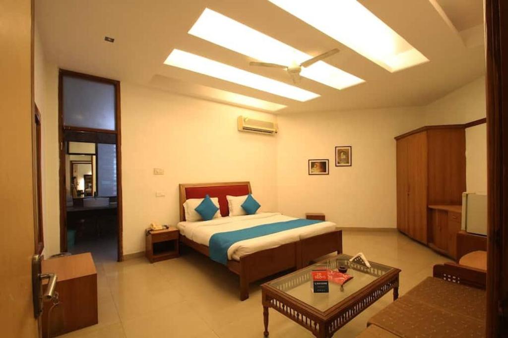 Un dormitorio con una cama y una sala de estar. en Hotel Angel Pink Residency Near EDM Mall, en Nueva Delhi