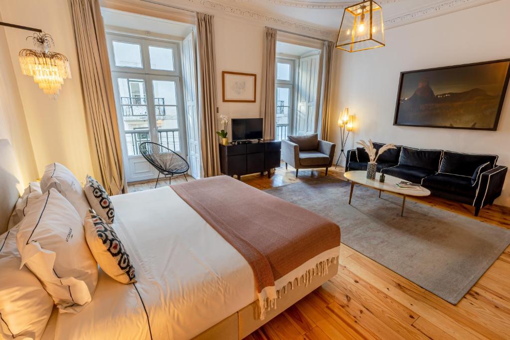 a bedroom with a large bed and a living room at Le Consulat in Lisbon