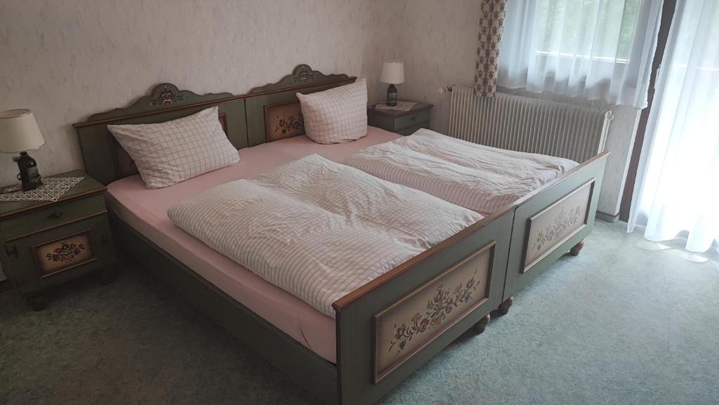 a bedroom with a large bed with white sheets and pillows at Café Pension Sonnenkanzel in Staatsbad Brückenau
