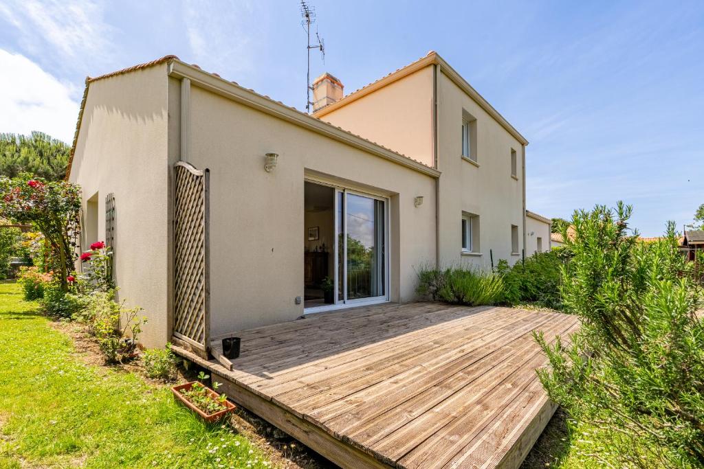 une maison avec une terrasse en bois devant elle dans l'établissement 99 Pornicaise 6p jardin clos, à Pornic