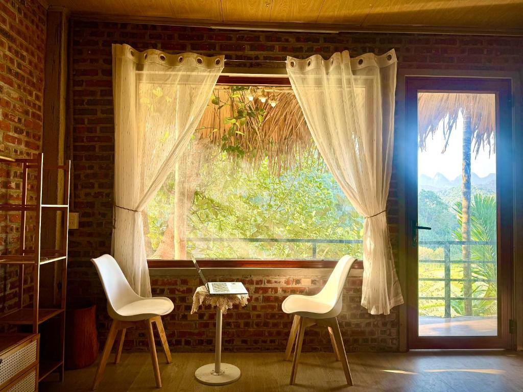 a room with two chairs and a window at Nếp homestay in Làng Xa