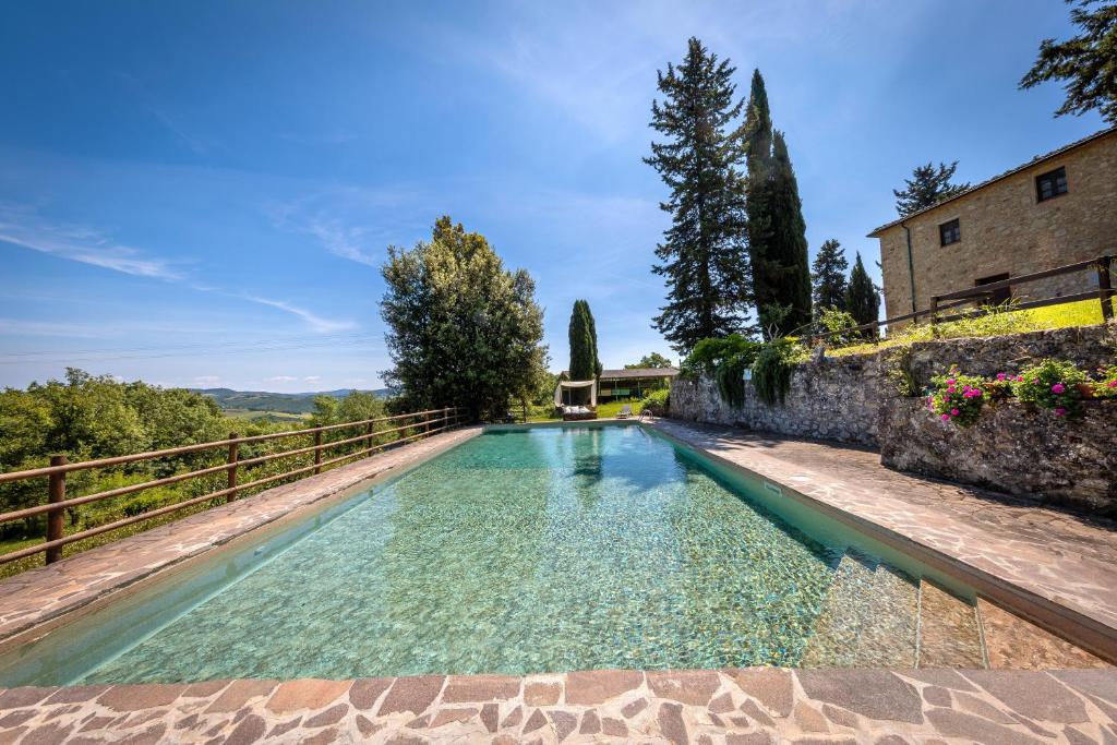 an infinity pool in a villa with a stone wall at Podere le Rote in Castelnuovo di Val di Cecina