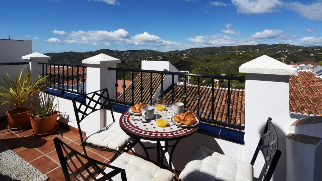 a balcony with a table with food on it at Casa Pegelow in Frigiliana