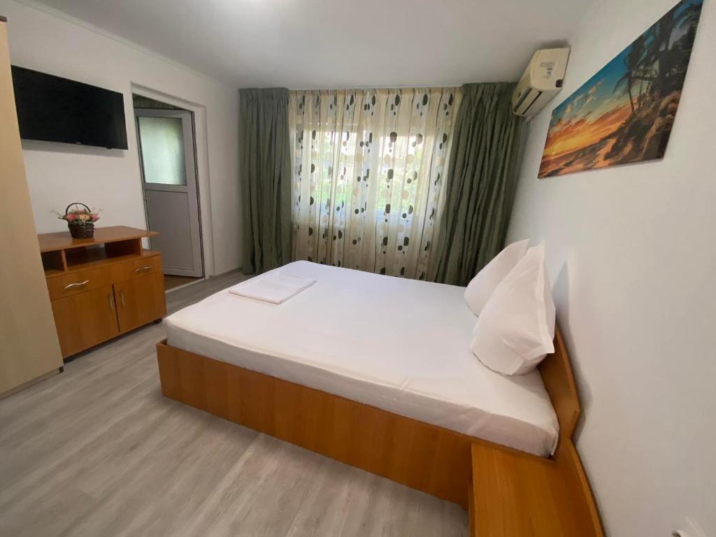 a bedroom with a large bed and a television at Apartament A2 - EVIM in Mangalia