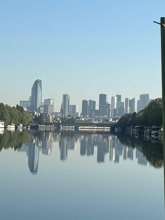 une vue sur une ville depuis une rivière avec des bâtiments dans l'établissement La cabine du capitaine, à Saint-Cloud