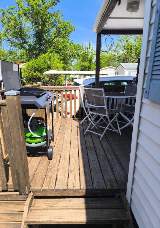 une terrasse en bois avec une table et des chaises dessus dans l'établissement La clé du réconfort, à Sainte-Croix-de-Verdon